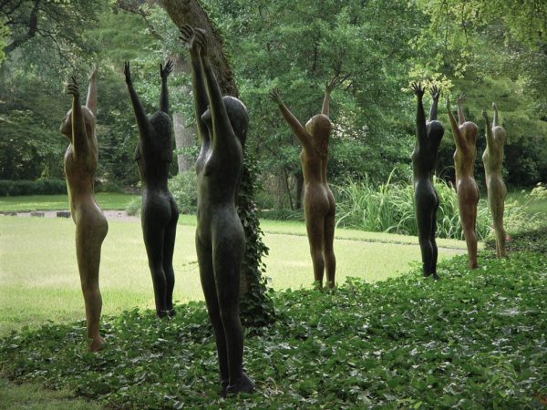 outdoor image of a line of figure sculptures with arms raised
