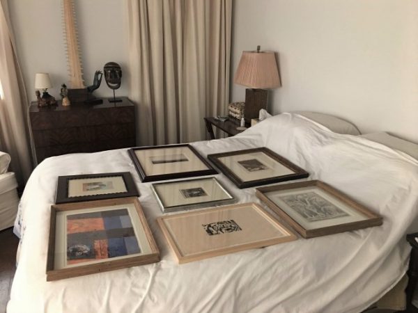 An image of artworks carefully placed on on a bed.