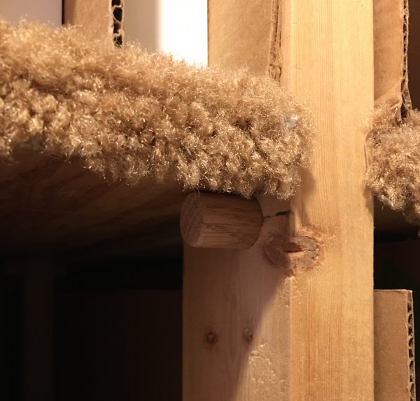 This image shows how dowels are used to hold shelves in place. In this case, a 1 inch hardwood dowel is inserted through a 2 x 4 support. Although not seen here, the dowel extends through the support to also hold the next shelf in place.