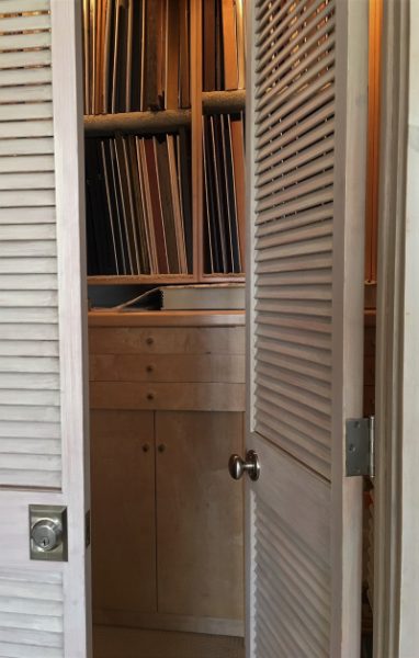 This image shows rack spaces that have been built into a walk-in closet. Two of the three structural boxes that make up the racks were built over a storage cabinet. The louver doors serve as an HVAC return.